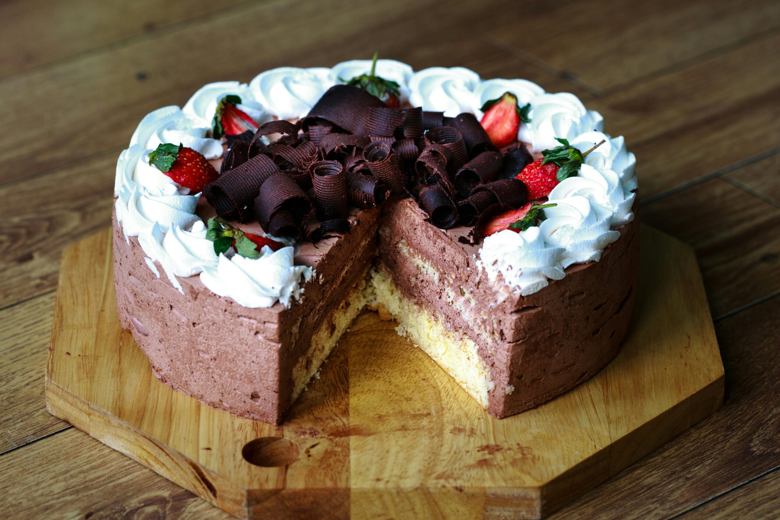 A visually enticing chocolate cake with strawberries and cream, perfect for desserts and celebrations.